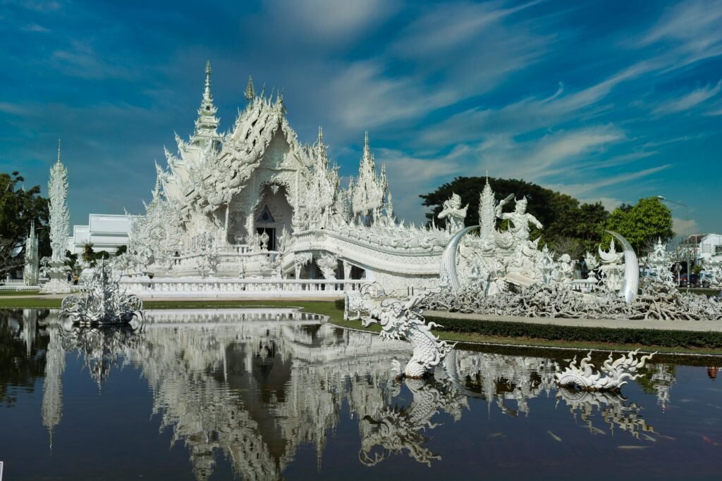 Beautiful detailed architecture of Wat Rong Khun temple in Chiang Rai with clear reflection.
