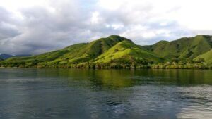 Scenic view of verdant hills and tranquil waters in Komodo, Indonesia.