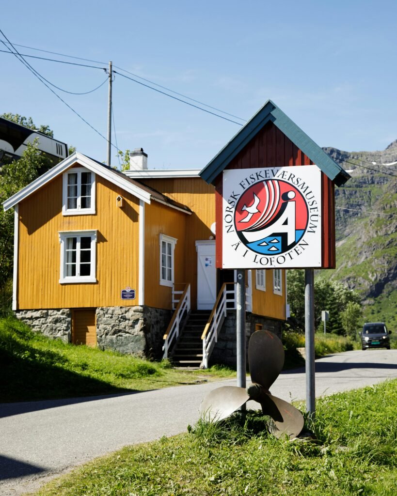 Sunlit wooden house by the Norsk Fiskeværsmuseum in Å, a picturesque village in Lofoten, Norway.