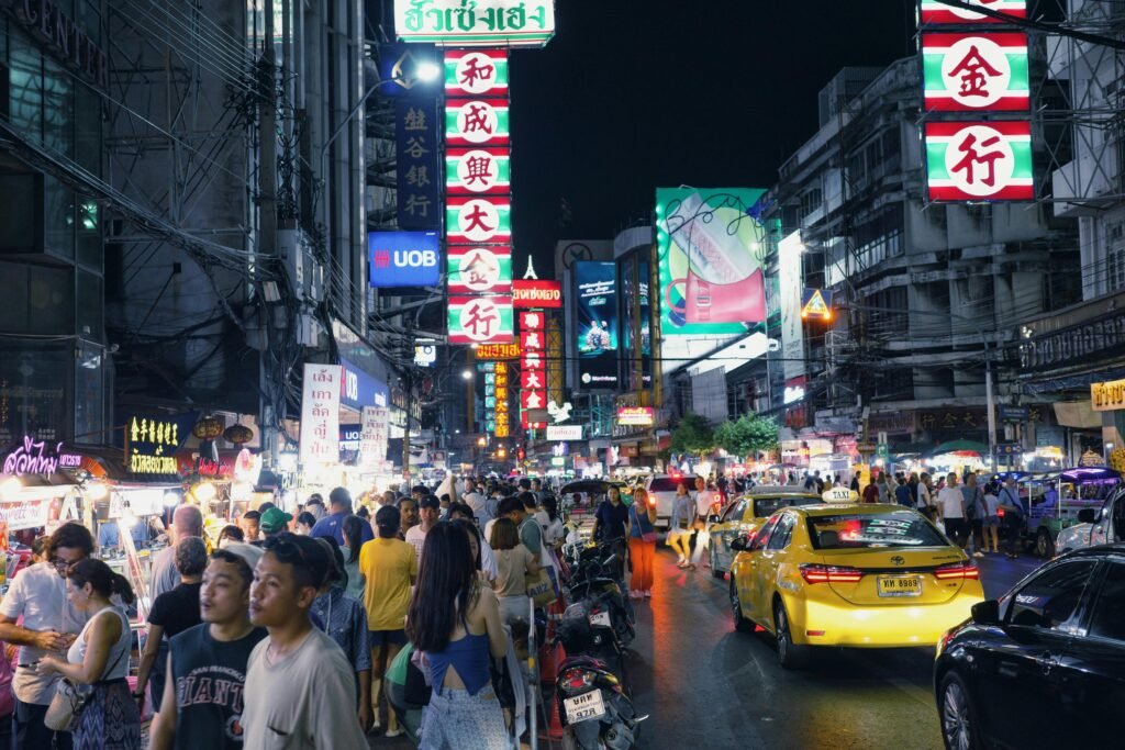 Lively city street at night with crowds, neon lights, and busy traffic. Immersive urban experience.
