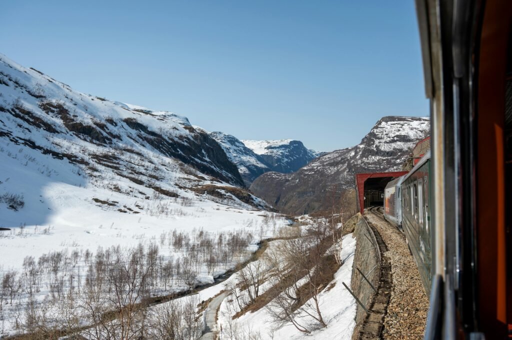 Experience an unforgettable train ride through snow-covered landscapes and majestic fjords in Flåm, Norway.