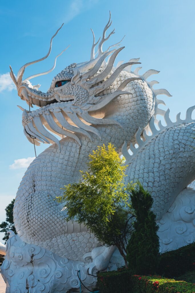 Stunning low-angle view of a white dragon sculpture at Wat Huay Pla Kang, Thailand.