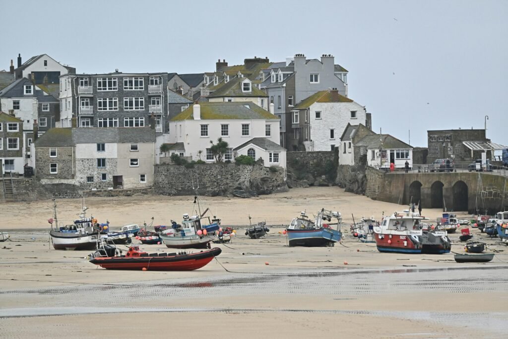 Charming view of St Ives harbour in England with fishing boats at low tide.