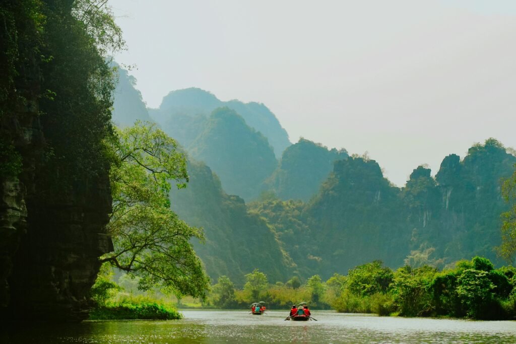 Peaceful river scene with tourists boating in Hoa Lư, Ninh Bình, Vietnam.