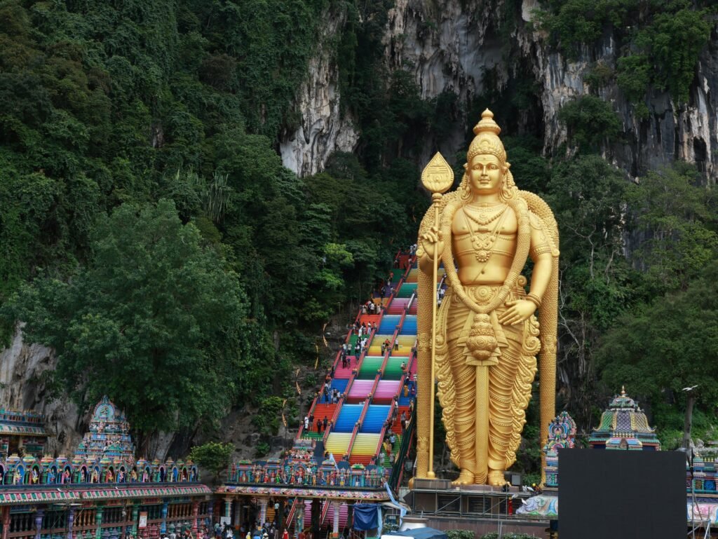 Vibrant steps leading to Batu Caves with the towering Lord Murugan statue in Kuala Lumpur.