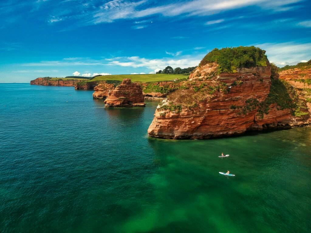 A breathtaking aerial view of the English coastline with kayakers and striking cliffs.