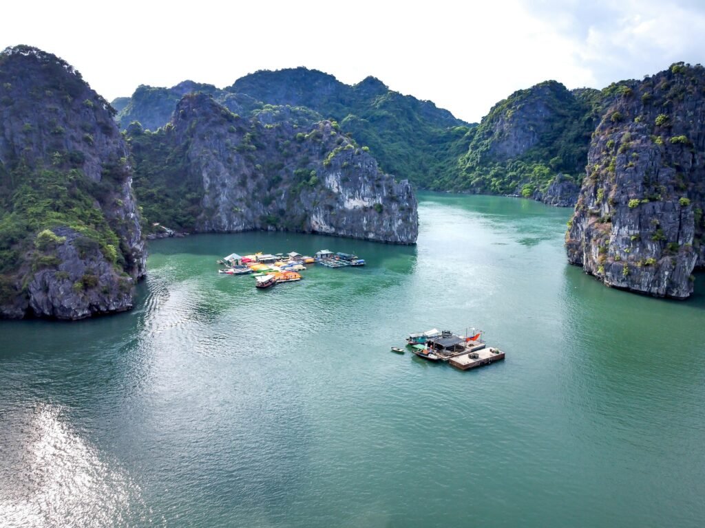 Scenic aerial view of boats in a tranquil bay surrounded by limestone cliffs.