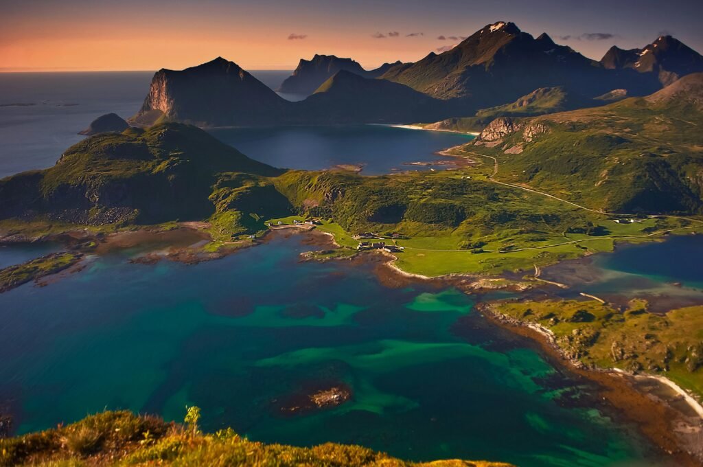 Beautiful aerial landscape of Lofoten Islands, Norway during sunset, showcasing mountains and ocean.