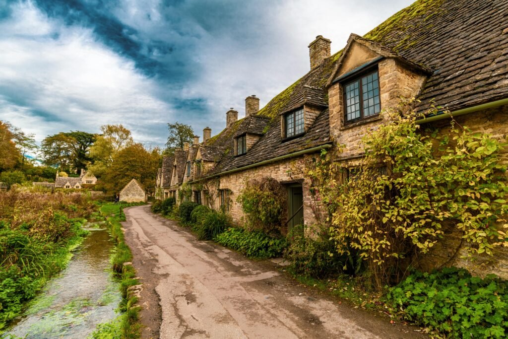 Picturesque stone cottages along a scenic road in Bibury, England, UK.