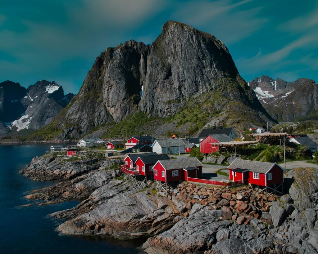 Picturesque Reine with red cabins and towering mountains in Nordland, Norway.