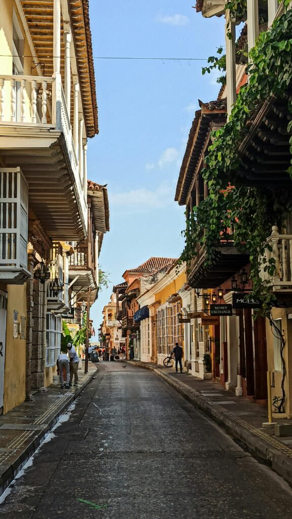 Scenic narrow alley in Cartagena's historic district with colonial architecture and clear sky.