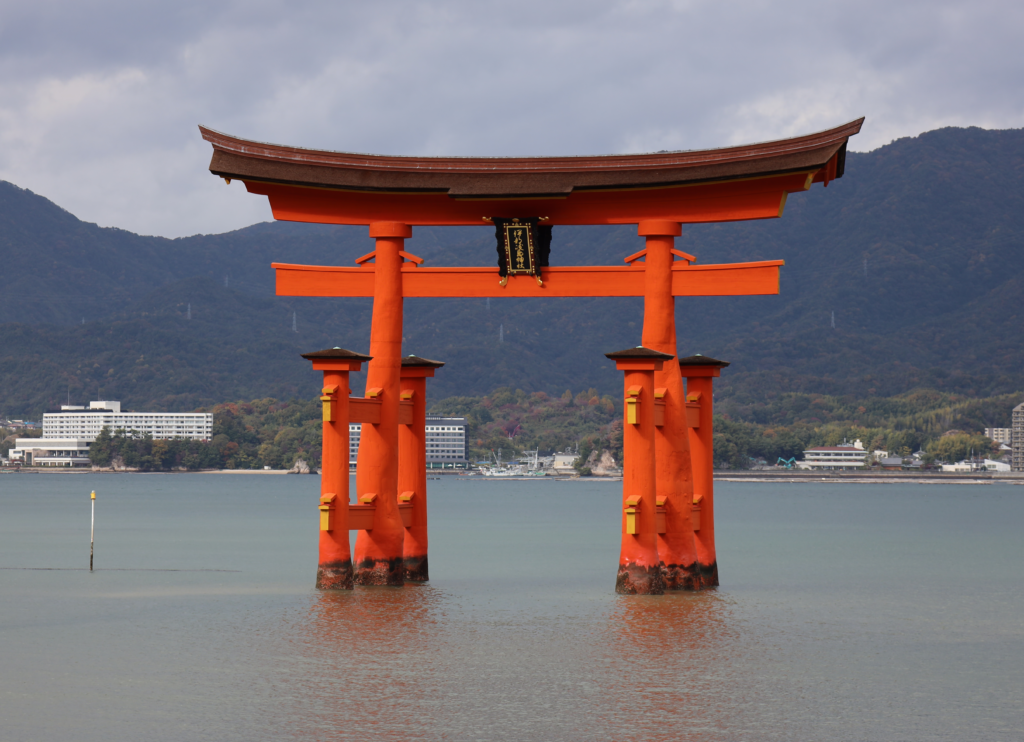 The famous floating Torii Gate at Itsukushima Shrine, set against mountainous backdrop.