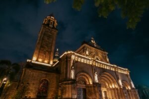 A dramatic night view of the illuminated Manila Cathedral showcasing its architectural beauty.