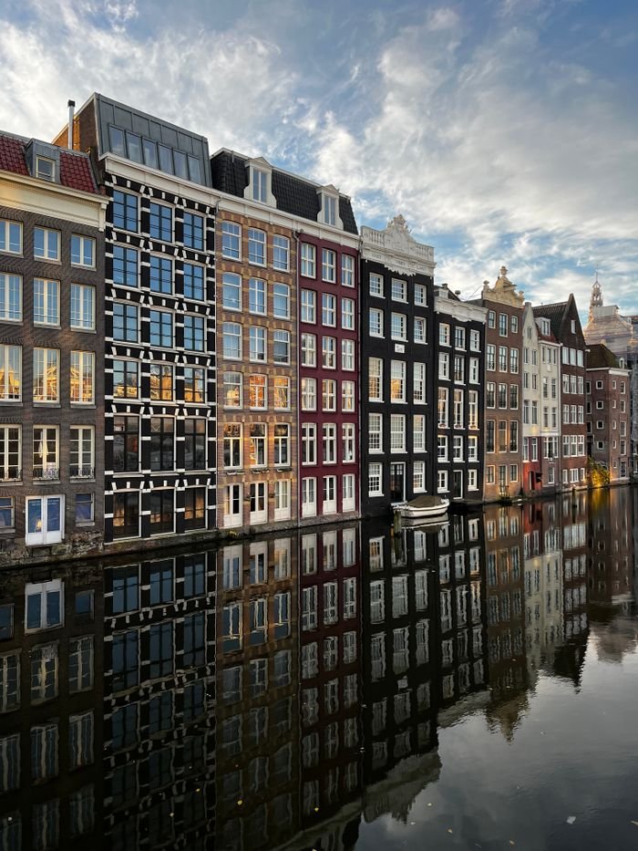 Beautiful reflection of Amsterdam canal houses at dusk.
